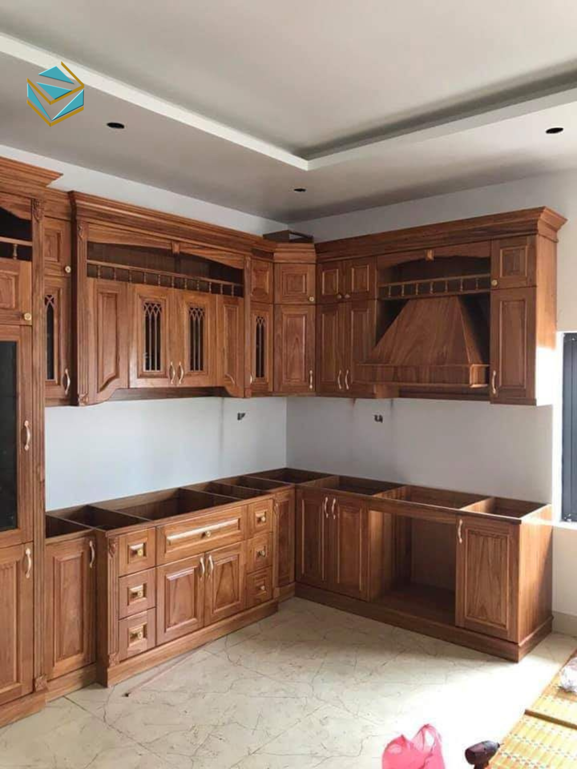 Mẫu tủ bếp gỗ tự nhiên được chạm khắc tinh xảo, phù hợp các căn bếp rộng và không gian thiết kế cổ điển châu Âu.